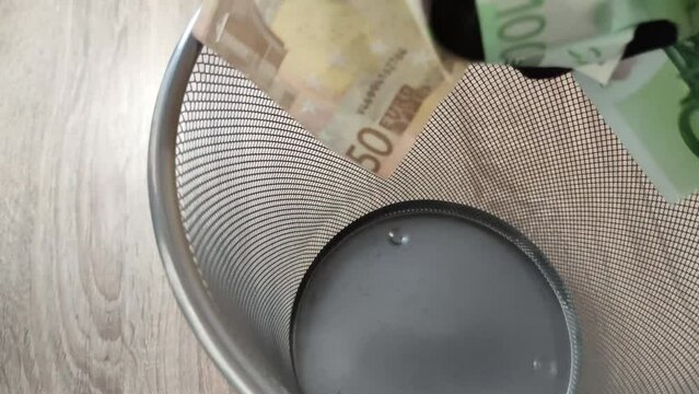 Recoger dinero tirado en la papelera