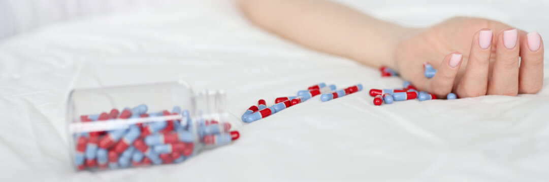 Dead Woman Lying On Bed With Scattered Medical Capsules Closeup