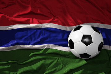 Fototapeta premium vintage football ball on the waveing national flag of gambia background. 3D illustration