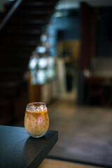 Ice coffee on a table with cream being poured into it showing the texture
