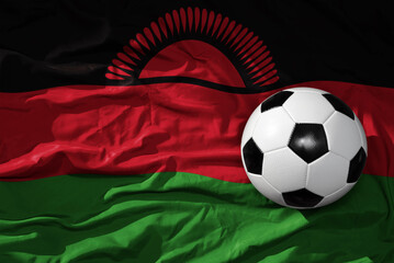 vintage football ball on the waveing national flag of malawi background. 3D illustration