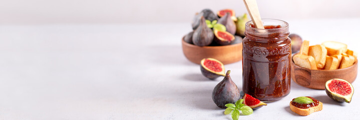 Fig jam or fig marmalade on wooden board with fresh, ripe figs