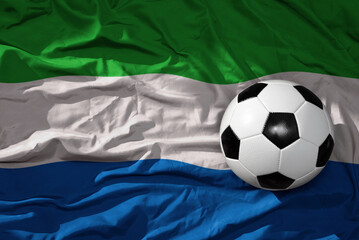 vintage football ball on the waveing national flag of sierra leone background. 3D illustration
