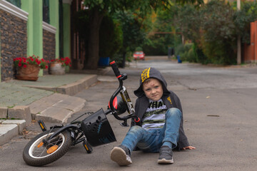 Preschooler boy  hurts his forehead after falling off his bicycle. Child is learning to ride a bike