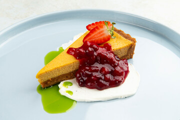 Dessert garnished with strawberries and jam in a bowl. on a gray background.