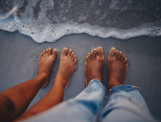 Couple feet, beach sand and water at ocean waves, nature and summer travel for vacation, honeymoon...