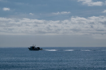 little fishing boat crossing the calm sea