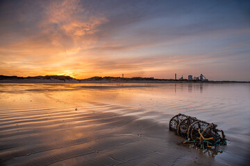 Sunset over beach and lobster pot