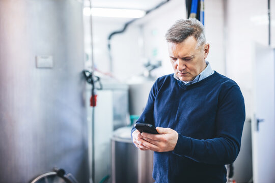 Craft brewery owner talking on mobile phone doing business