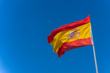 Spanish flag, symbol of patriotism held by the wind, red and yellow national symbol