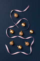 Christmas card with golden glitter balls and satin ribbon on dark blue background