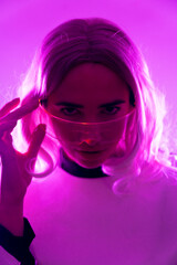 A woman in a futuristic suit and glasses with pink lights, virtual or metaverse concept