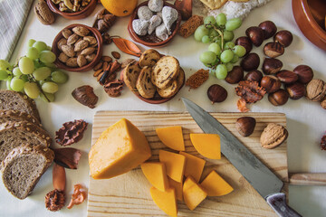 Table with a variation of autumn fruits. Background with fruit, nuts and pumpkin. All Saints Day.