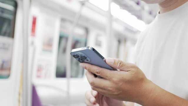 midaged chineseman using mobile phone in subway