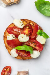 Open sandwiches with cherry tomatoes, mini mozzarella, fresh basil leaves, caprese on bread, Traditional italian appetizer or snack, antipasto. banner, menu, recipe place for text, top view
