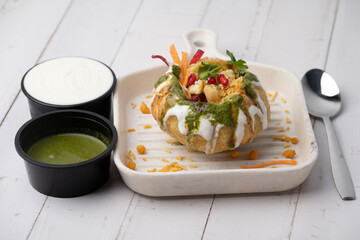 Rajasthani Shahi Raj-Kachori, stuffed with potato and sprout filling. served with curd, chutney and sev in a plate © Ojas