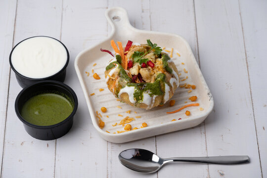 Rajasthani Shahi Raj-Kachori, stuffed with potato and sprout filling. served with curd, chutney and sev in a plate