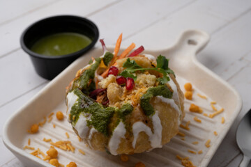 Rajasthani Shahi Raj-Kachori, stuffed with potato and sprout filling. served with curd, chutney and sev in a plate