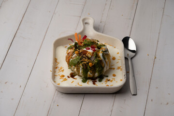 Rajasthani Shahi Raj-Kachori, stuffed with potato and sprout filling. served with curd, chutney and sev in a plate © Ojas
