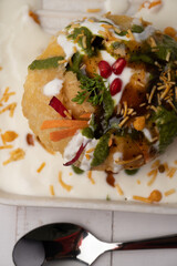 Rajasthani Shahi Raj-Kachori, stuffed with potato and sprout filling. served with curd, chutney and sev in a plate