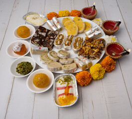 Mix indian sweets like kaju roll dryfruits barfi mango peda served in a plate