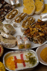 Mix indian sweets like kaju roll dryfruits barfi mango peda served in a plate