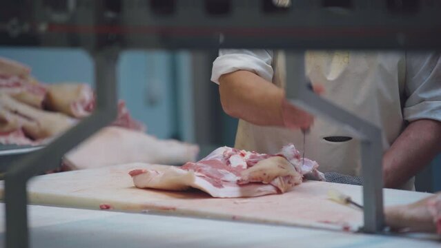 Meat factory. Cutting pork ham at a meat production company.
