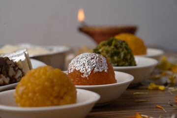 Mix indian sweets like kaju roll dryfruits barfi mango peda served in a plate