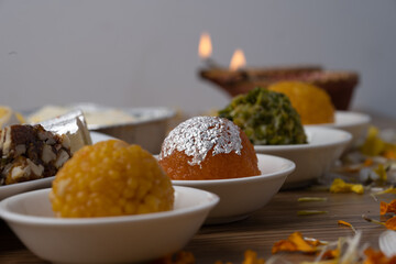Mix indian sweets like kaju roll dryfruits barfi mango peda served in a plate