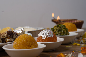 Mix indian sweets like kaju roll dryfruits barfi mango peda served in a plate