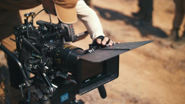 cameraman adjusts the camera before shooting a movie in the steppe