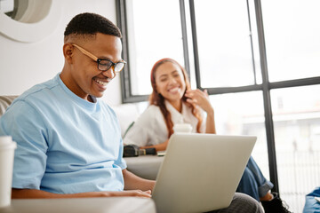 Man, laptop and startup smile with woman coworking marketing, social media or seo project on internet. Black man, happy and computer in office with girl in teamwork collaboration for advertising job