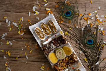 Indian sweets served in plate. variety of Peda, burfi, laddu in decorative plate, selective focus
