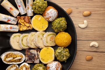Group of Indian assorted sweets or mithai with diya

