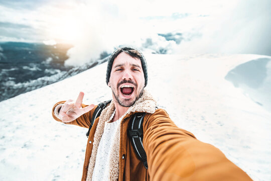 Handsome man taking selfie on winter snow mountain 