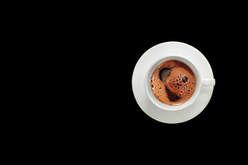 A cup of foamy Turkish coffee on a black background