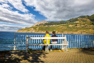 Old couple watching the sea on an autumn day, in the fishermen´s village of Mundaka - Biscay, Spain.