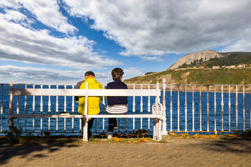 Old couple watching the sea on an autumn day, in the fishermen´s village of Mundaka - Biscay,...
