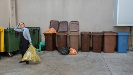 professional woman waitress who is going to throw the rubbish into the rubbish bins, recycle plastic. place with rubbish bins for recycling, coloured rubbish bins, 