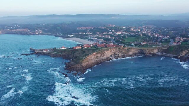 Cinematic Shot Of Beautiful Cantabria Village Located On Distinctive Foggy Comillas Coast, Spain