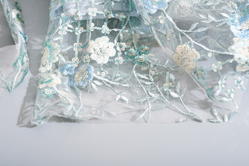 details of glamour shiny lace dress with sequins and hand made embroidery. floral ornament on wedding or party dress.