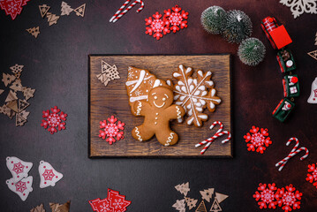 Christmas decoration elements as well as gingerbread on a brown concrete background