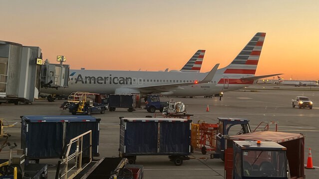American Airlines planes parked at the gate at Chicago O'Hare International Airport at sunset.