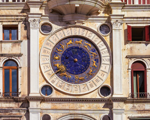 Saint Mark's Clock Tower in Saint Mark's Square (Piazza San Marco), Venice, vintage clock with golden zodiac signs and Roman dial, early Italian Renaissance architectural monument in Venice