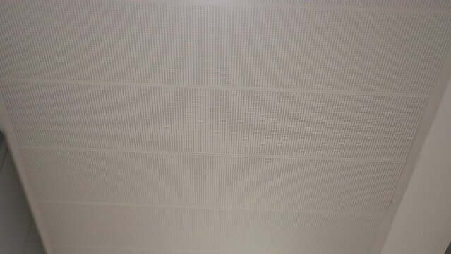 Ceiling through the eyes of a man walking along a long corridor.POV