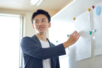 プレゼンテーションを行う若い日本人のビジネスマン