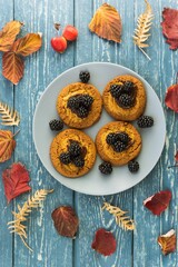 Homemade cookies on a wooden background and autumn fallen leaves. Sweet autumn baking concept.