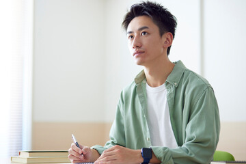 教室で勉強をする若い日本人の学生