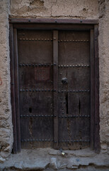 old wooden door in Nizwa, Oman, This door is more than 100 years old and has Islamic decorations and verses from the Holy Quran.