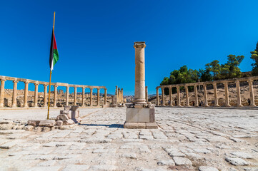 A view past a column across the Oval Plasa in the ancient Roman settlement of Gerasa in Jerash,...